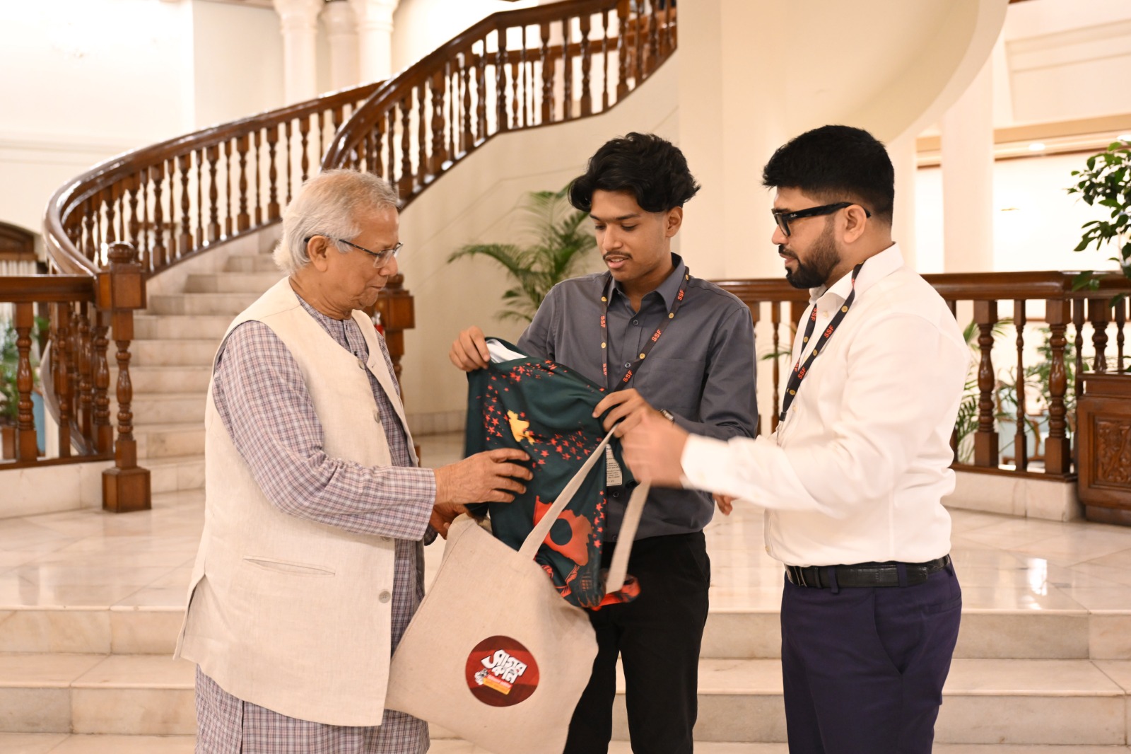 Mahir Sarowar Megh presents a jersey and bag to Chief Adviser Professor Muhammad Yunus as a gesture of gratitude during the deed handover ceremony in Dhaka on August 21, 2025. Photo: AH Mintu/V7N